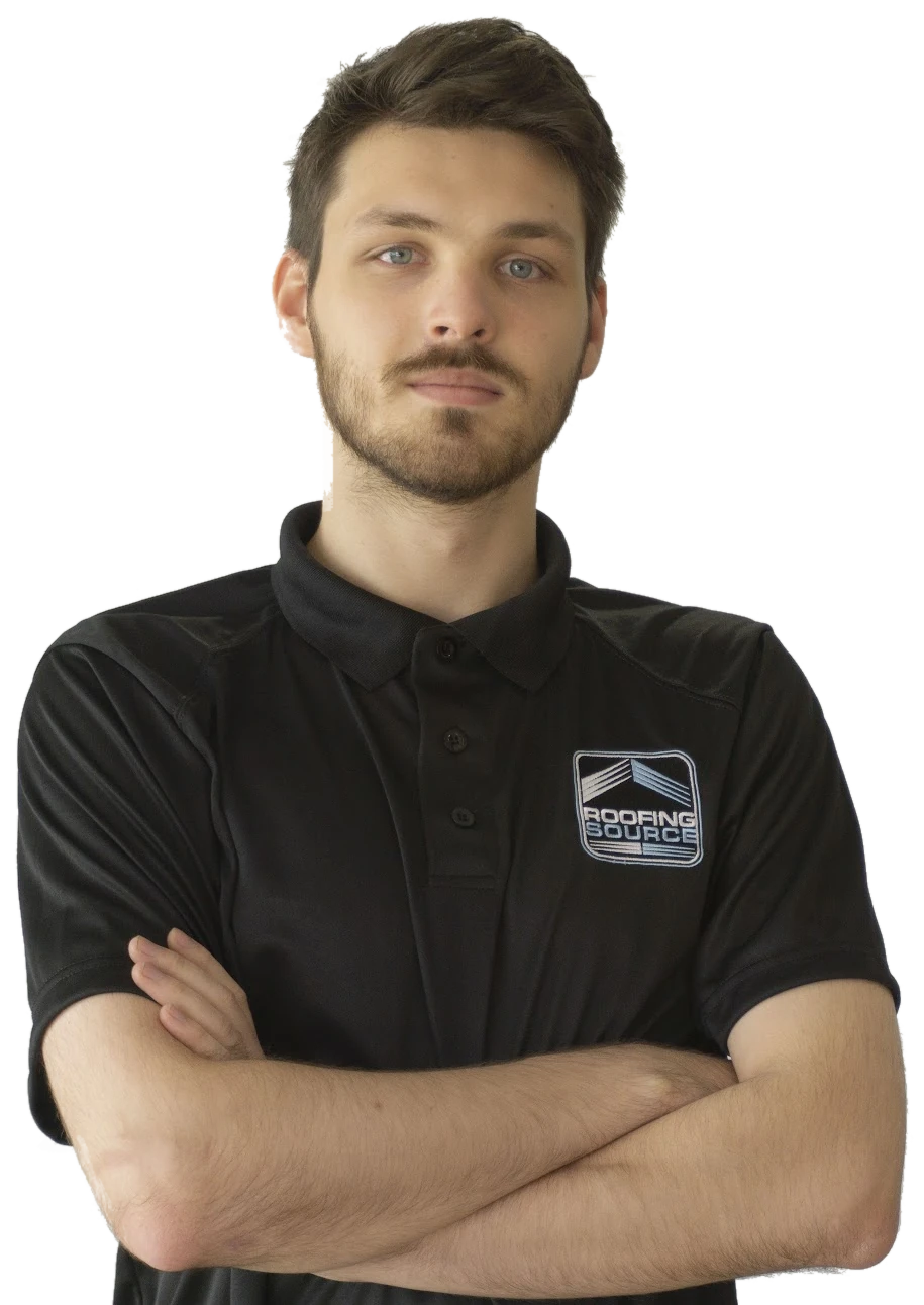A RoofingSource teammate in a black company polo, arms folded