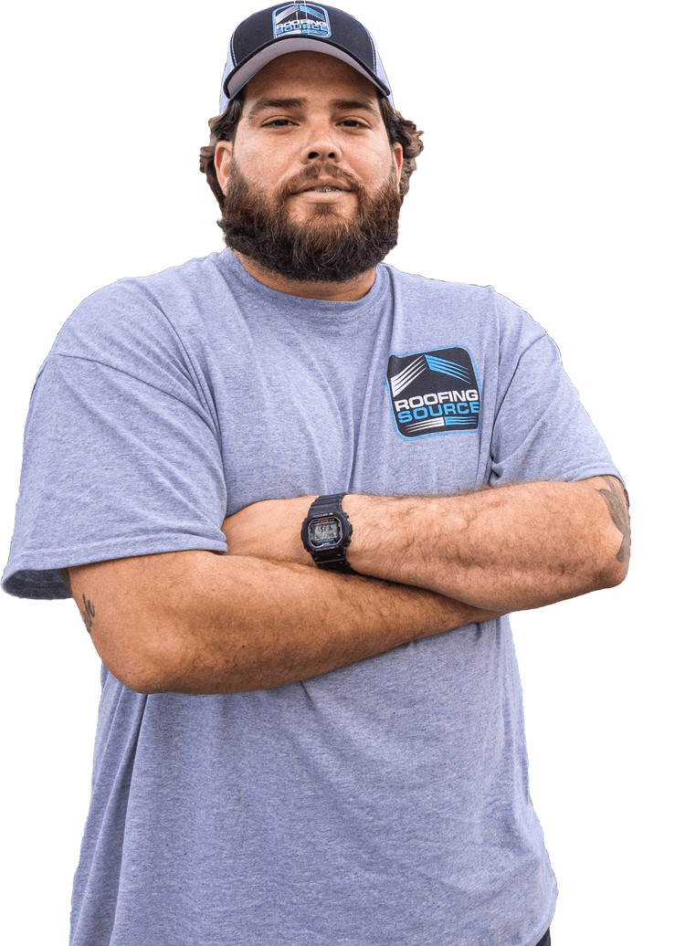 Un compañero de RoofingSource con camiseta gris y gorra, de brazos cruzados