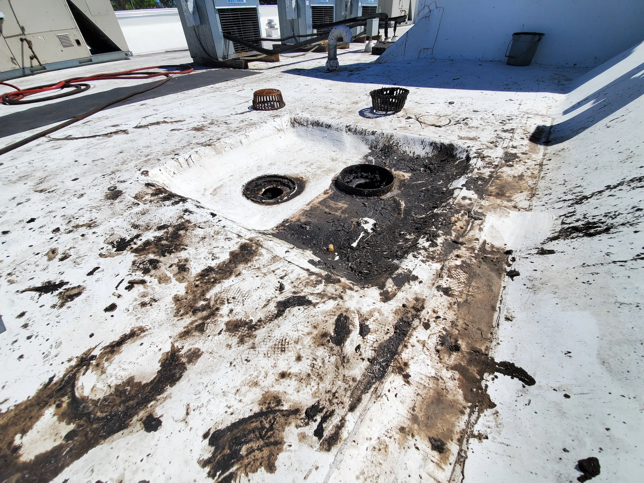 A commercial roof membrane heavily stained by ventilator grease