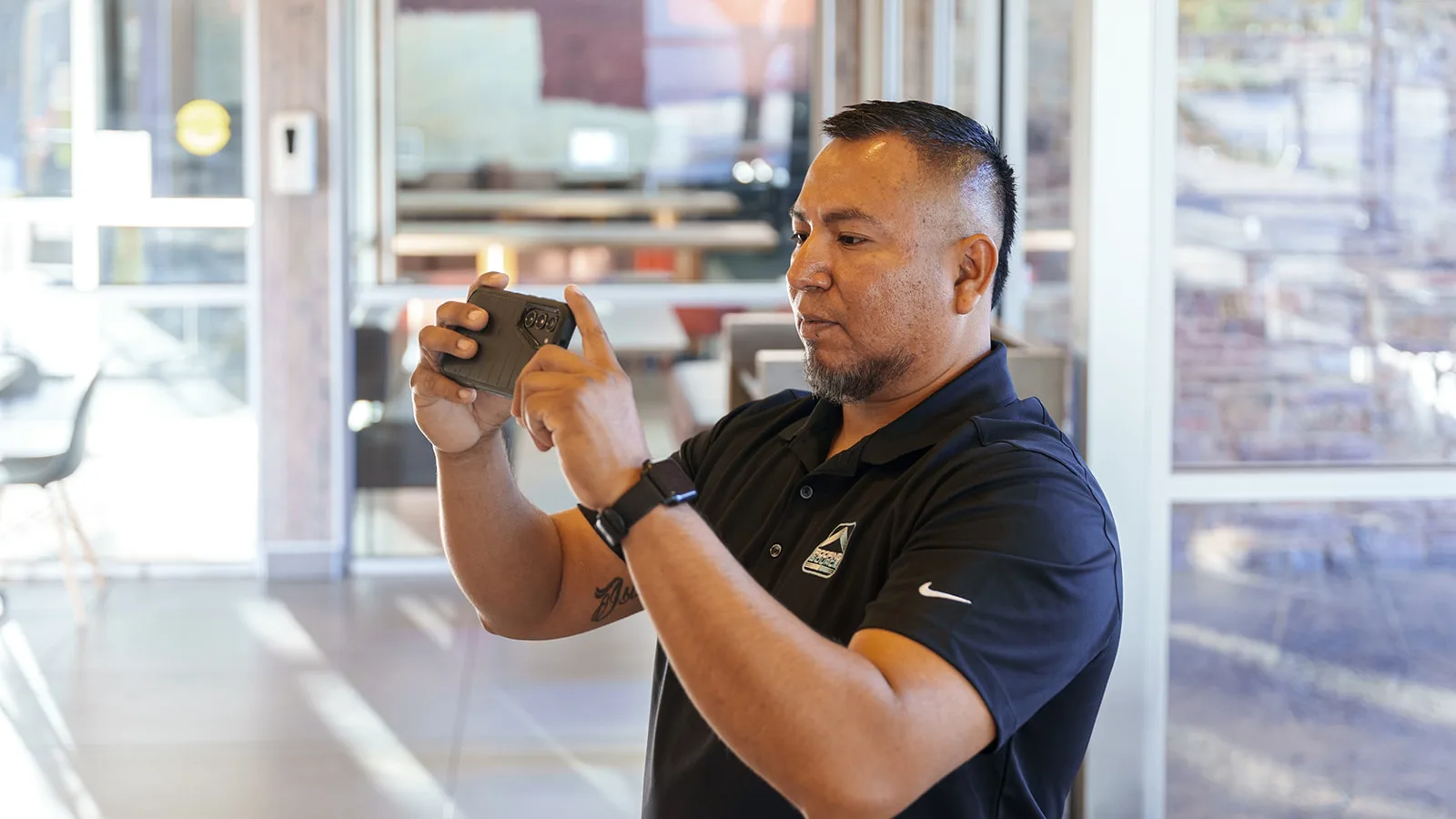 A RoofingSource teammate photographing the ceiling inside a restaurant dining room