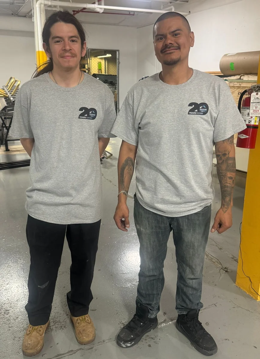 Two RoofingSource teammates in twentieth-anniversary shirts at headquarters