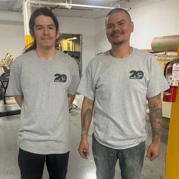 Two RoofingSource teammates in twentieth-anniversary shirts