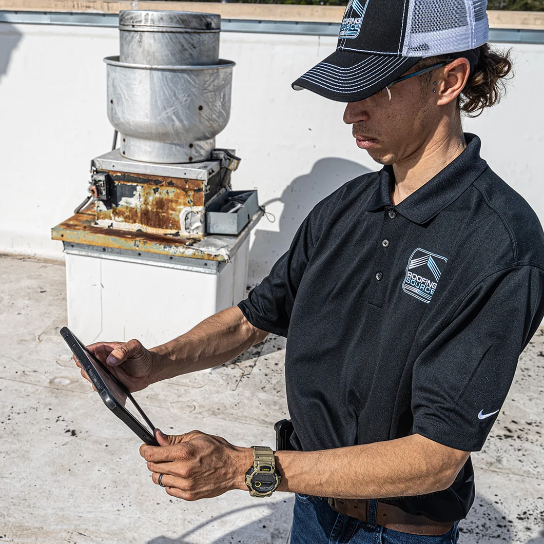 A Field Advisor logging a rooftop grease unit on his tablet