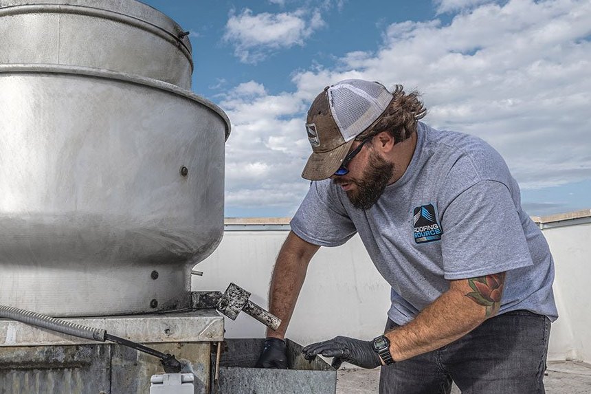 A rooftop grease containment unit serviced by a RoofingSource Field Advisor