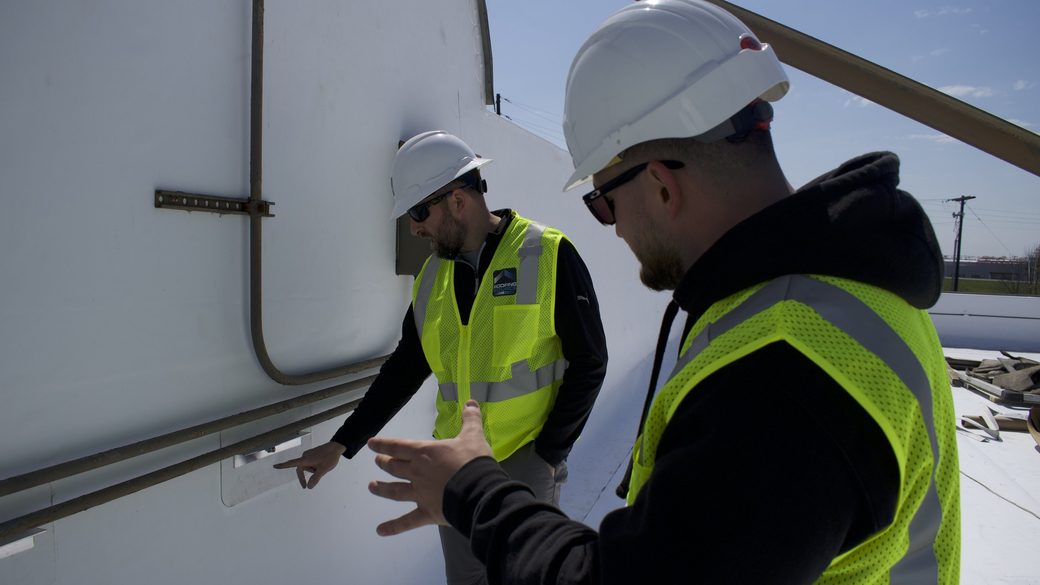 RoofingSource teammates inspecting rooftop equipment